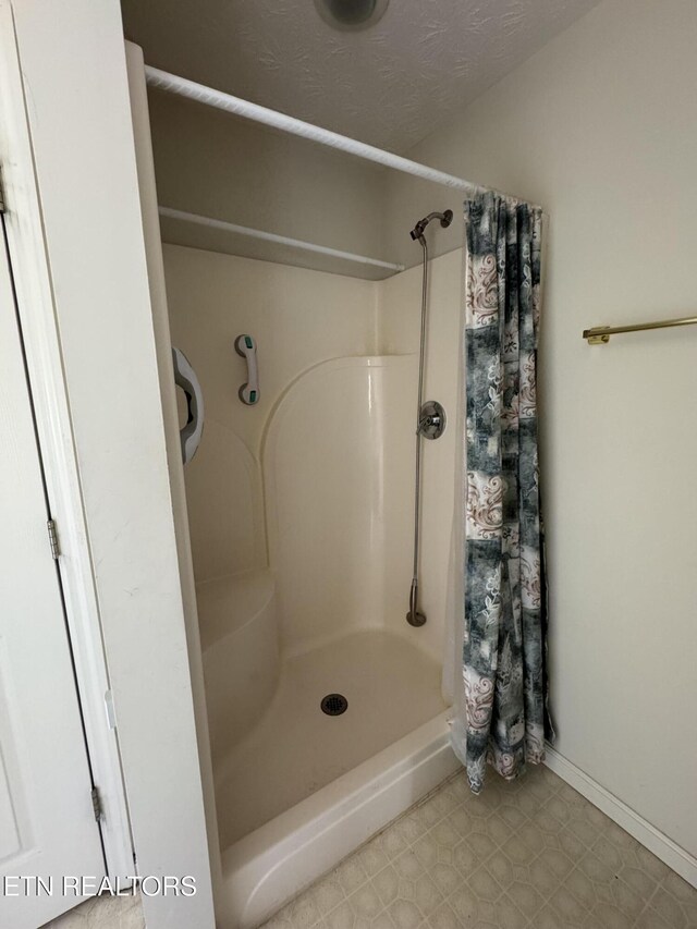 bathroom with walk in shower and a textured ceiling