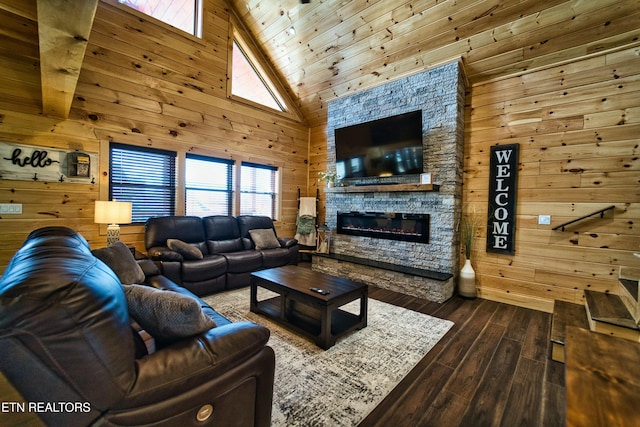 living room featuring hardwood / wood-style floors, a stone fireplace, and wood walls