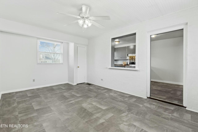 unfurnished bedroom with ceiling fan and brick wall