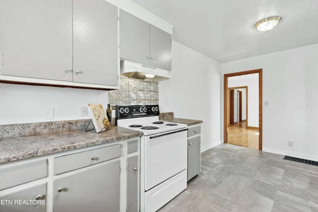 kitchen featuring white electric stove and backsplash