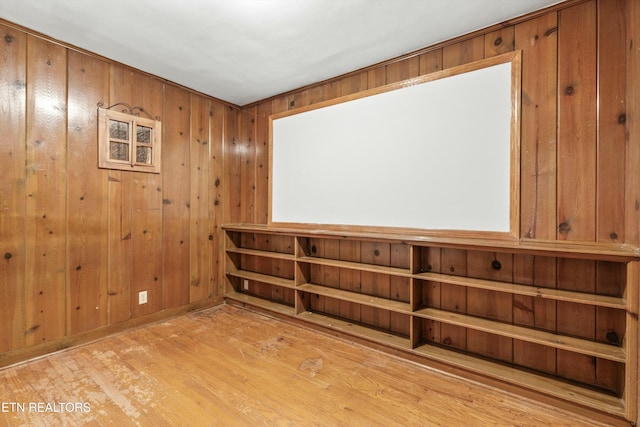 empty room featuring wooden walls and light wood-type flooring