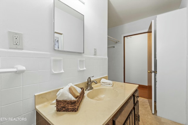 bathroom featuring vanity and tile walls