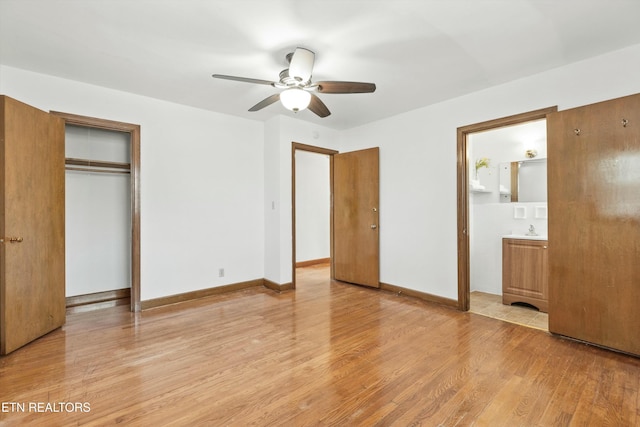 unfurnished bedroom featuring sink, ceiling fan, ensuite bathroom, light hardwood / wood-style floors, and a closet