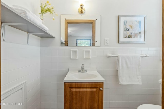 bathroom with vanity and tile walls