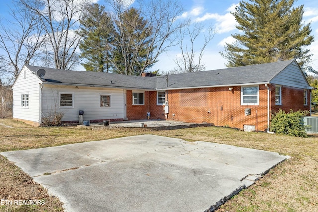 back of property featuring cooling unit, a patio area, and a lawn