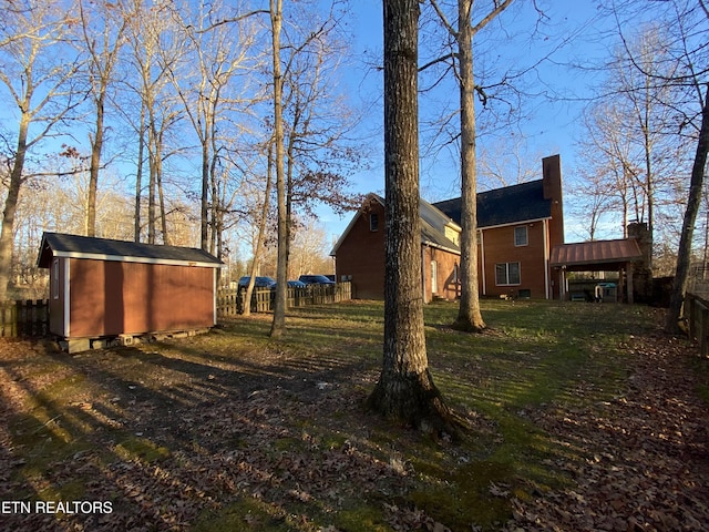 view of yard featuring an outbuilding, a shed, and fence