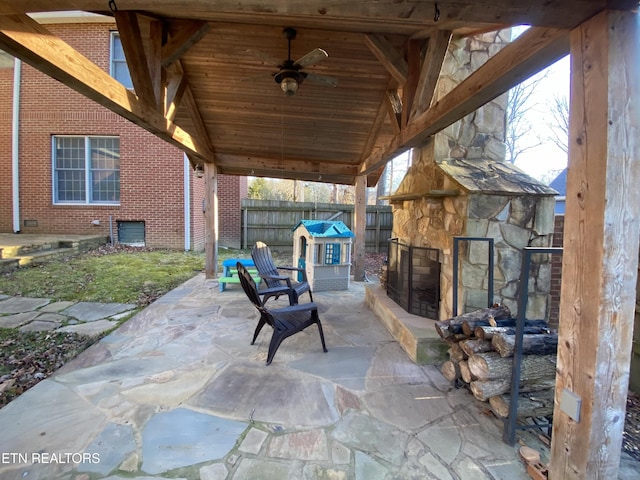 view of patio with ceiling fan and an outdoor stone fireplace