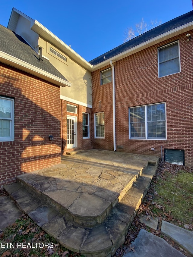 rear view of house featuring a patio area and brick siding