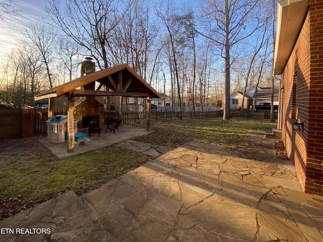 view of patio / terrace featuring a gazebo and exterior fireplace