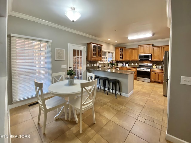 dining room with light tile patterned floors, ornamental molding, visible vents, and baseboards