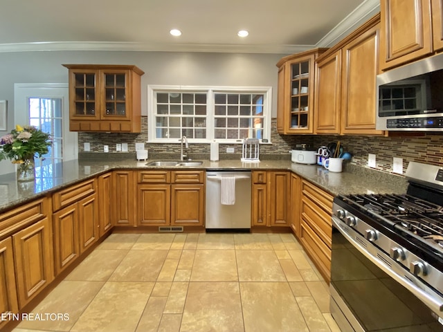 kitchen featuring stainless steel appliances, a sink, visible vents, and brown cabinets