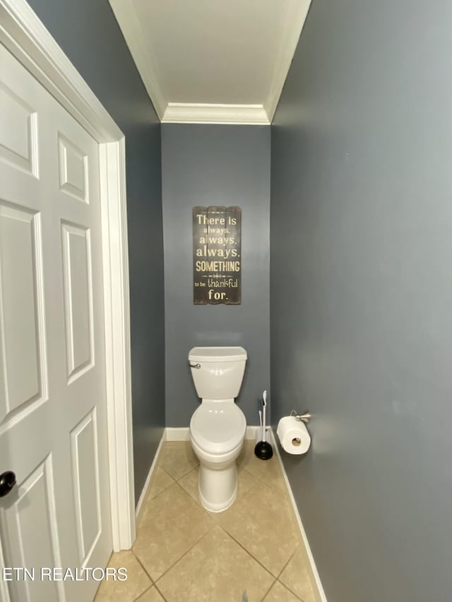 bathroom featuring toilet, baseboards, ornamental molding, and tile patterned floors