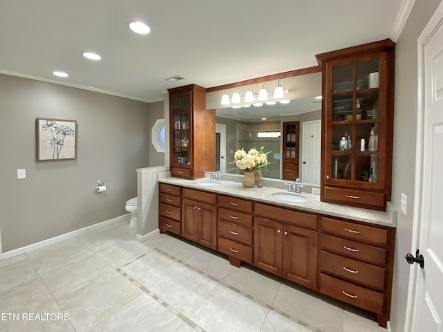 bathroom featuring a shower with door, crown molding, vanity, and toilet