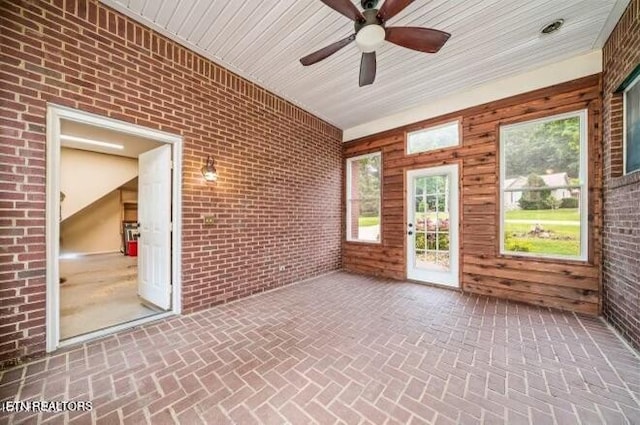 unfurnished sunroom with ceiling fan