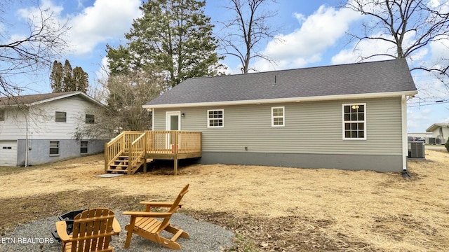 back of property with a wooden deck and central AC