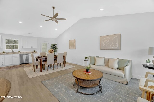 living room featuring sink, vaulted ceiling, light hardwood / wood-style floors, and ceiling fan