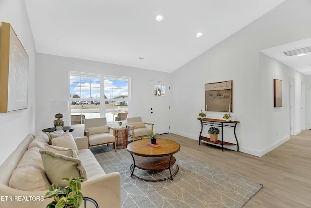 living room with light hardwood / wood-style flooring and vaulted ceiling