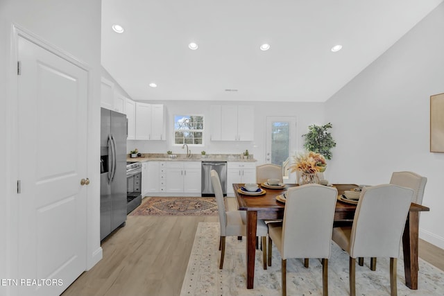 dining room with sink and light wood-type flooring