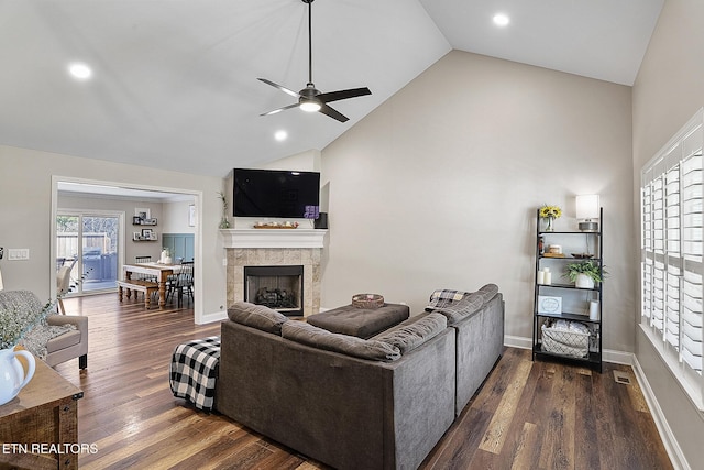 living room with ceiling fan, high vaulted ceiling, dark wood-type flooring, and a fireplace