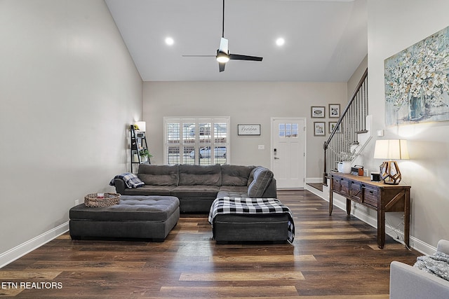 living room featuring ceiling fan, dark hardwood / wood-style flooring, and a high ceiling