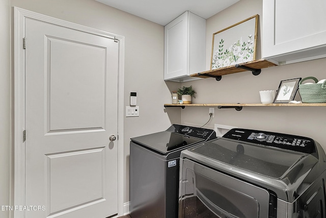 clothes washing area featuring washing machine and dryer and cabinets