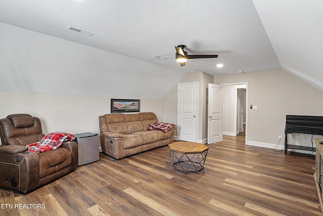 living room featuring dark wood-type flooring, ceiling fan, and vaulted ceiling