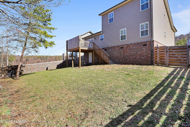 rear view of property with a wooden deck and a lawn