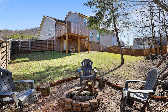 view of yard with a wooden deck and a fire pit