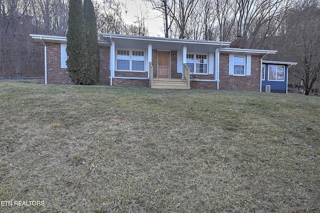 view of front facade with a front yard, brick siding, and a chimney