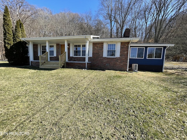 single story home with brick siding, a chimney, a porch, a front yard, and crawl space