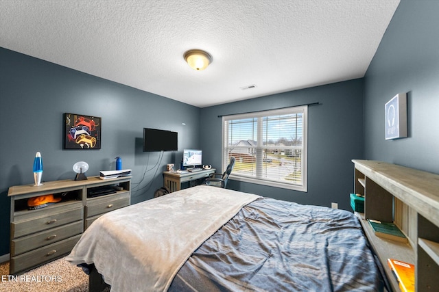 bedroom featuring carpet and a textured ceiling