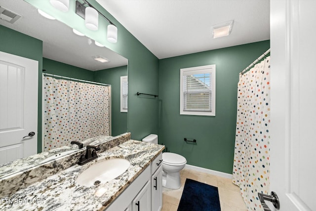 bathroom with vanity, tile patterned floors, toilet, and walk in shower