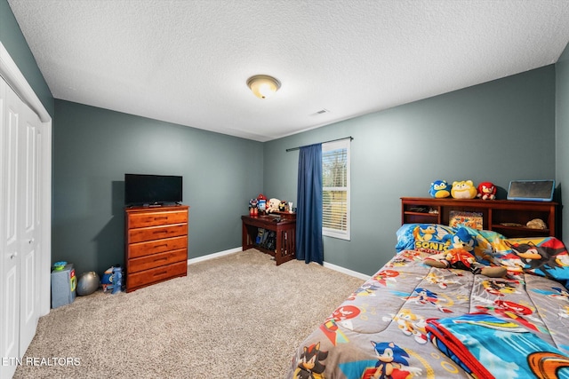 bedroom with carpet floors, a textured ceiling, and a closet