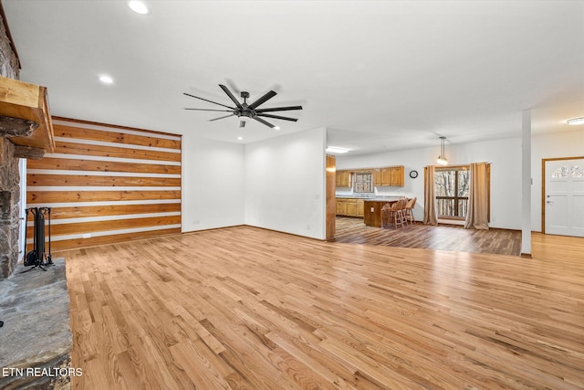 unfurnished living room with ceiling fan and light wood-type flooring