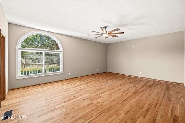 empty room with ceiling fan, light hardwood / wood-style floors, and a textured ceiling