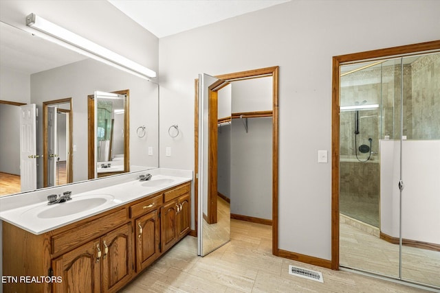 bathroom with vanity and a shower with door