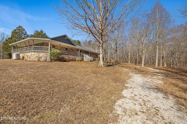 view of yard with central AC and covered porch