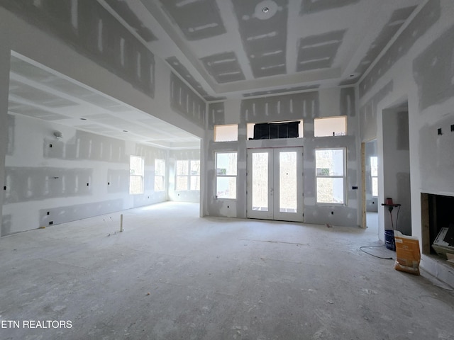 unfurnished living room with french doors and a towering ceiling