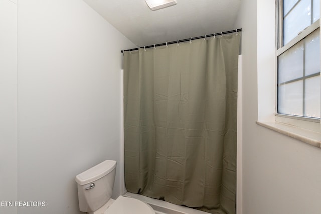 bathroom featuring toilet and a shower with shower curtain