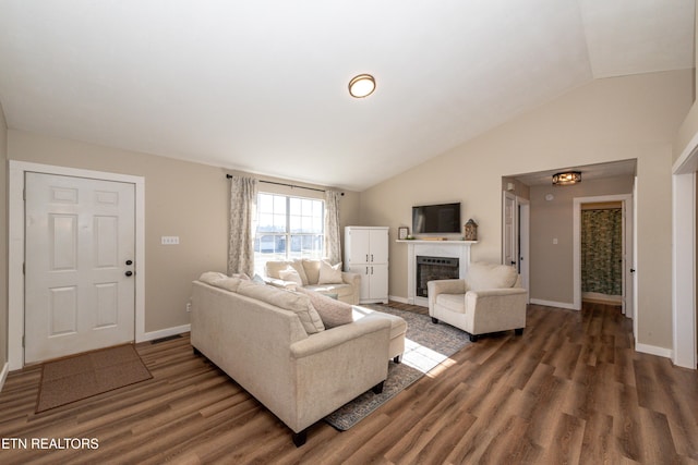 living room featuring dark hardwood / wood-style floors and vaulted ceiling