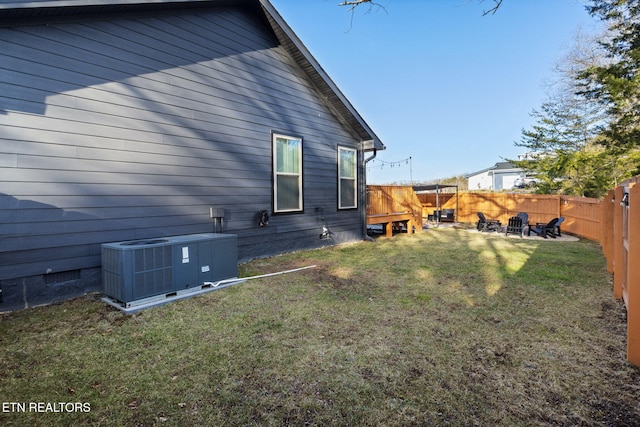 view of side of home featuring cooling unit and a lawn