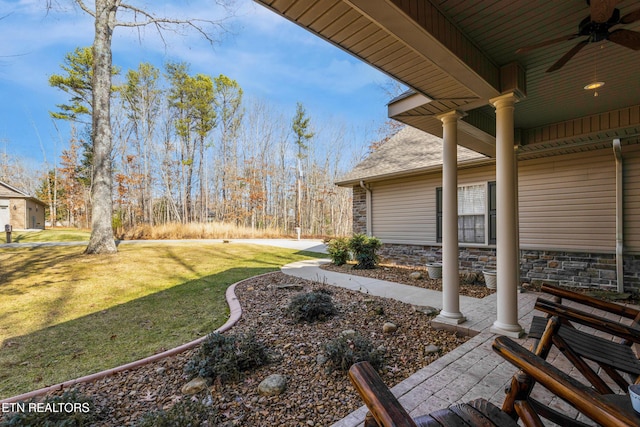 view of yard featuring covered porch and ceiling fan