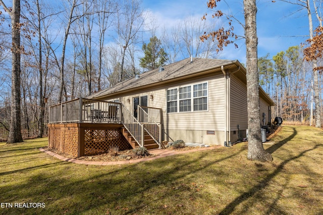 rear view of property with a yard and a deck