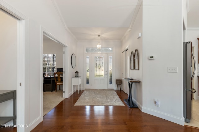 foyer featuring dark hardwood / wood-style flooring, crown molding, and a healthy amount of sunlight