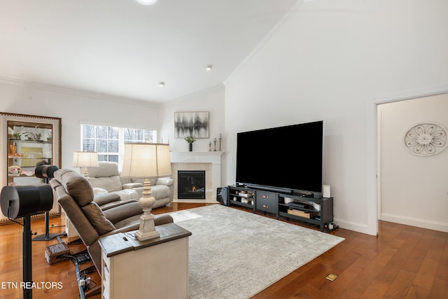 living room with a tile fireplace, crown molding, vaulted ceiling, and dark hardwood / wood-style flooring