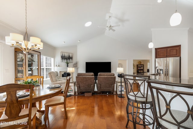 dining space featuring ornamental molding, lofted ceiling, dark hardwood / wood-style floors, and ceiling fan with notable chandelier