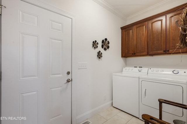 laundry area with light tile patterned flooring, cabinets, ornamental molding, and separate washer and dryer