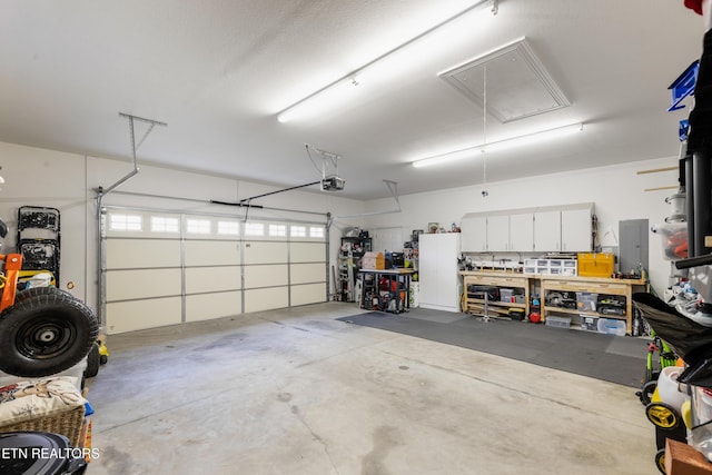 garage featuring a garage door opener and a workshop area