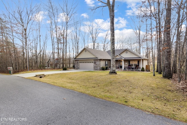 view of front of home featuring a porch, a garage, and a front lawn