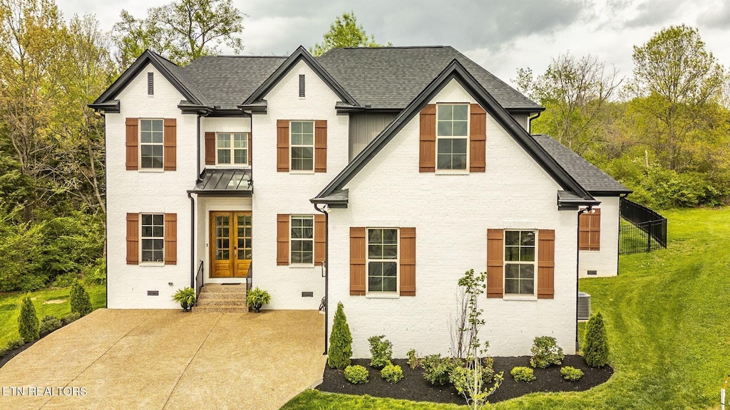 view of front of property featuring central AC, a front yard, and french doors